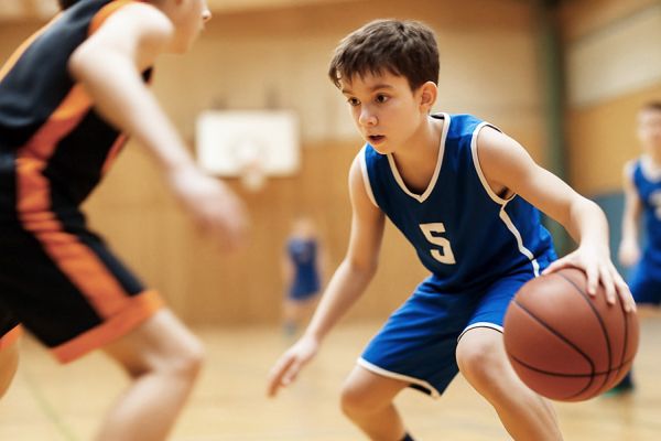 Zweikampf zweier Jugendlicher während eines Baskettballspiels